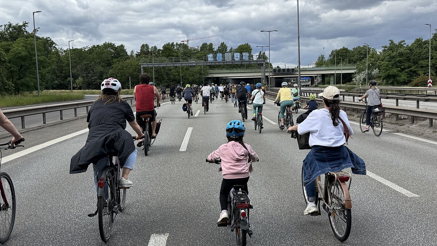Erwachsene Radfahrende und Kinder auf der Autobahn