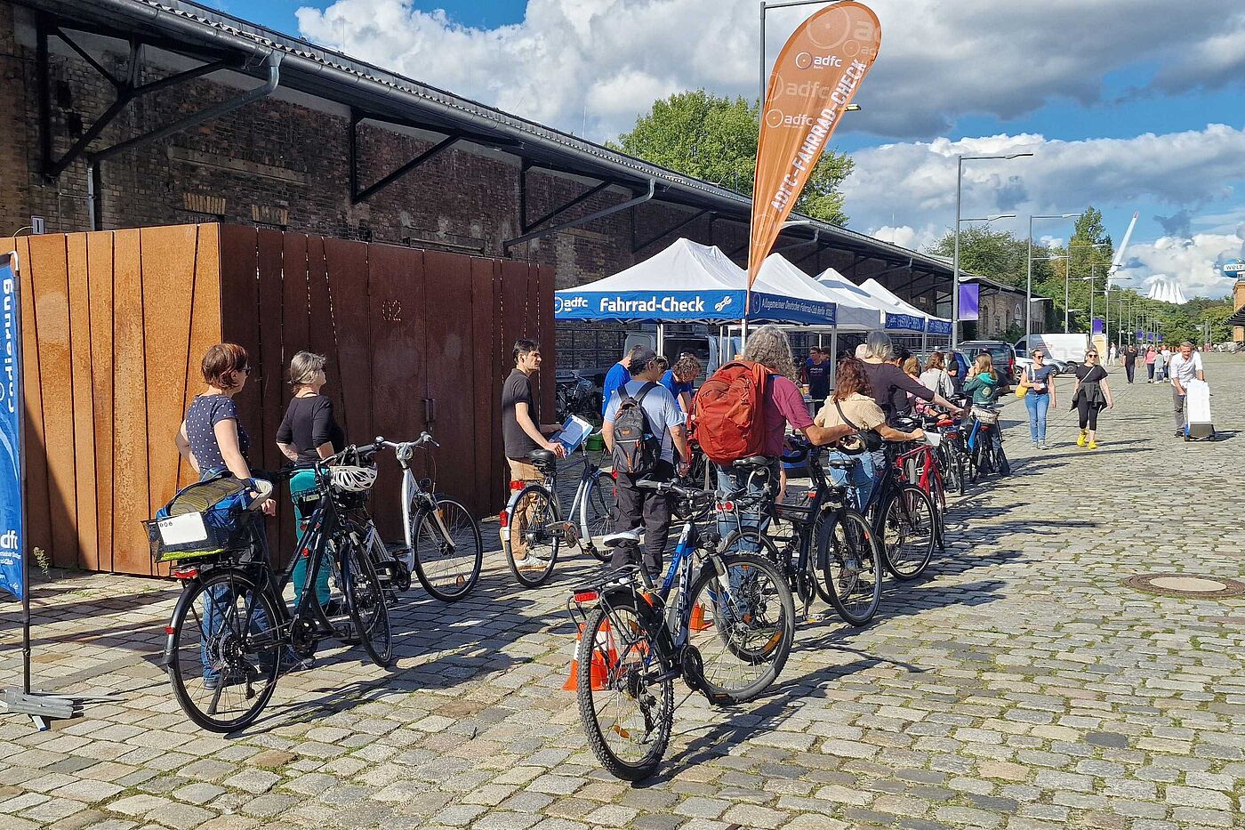 Menschen stehen mit ihren Fahrrädern in der Schlange für den ADFC-Fahrrad-Check