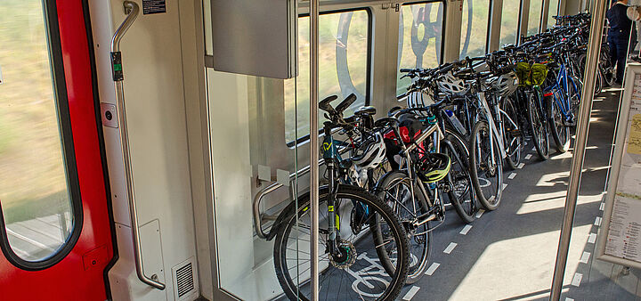 Das Bild zeigt ein Fahrradabteil im Zug mit vielen Rädern
