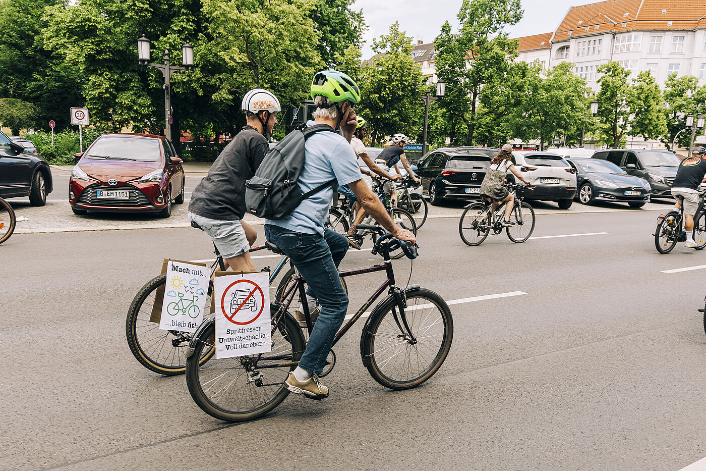 Radfahrende mit Schildern