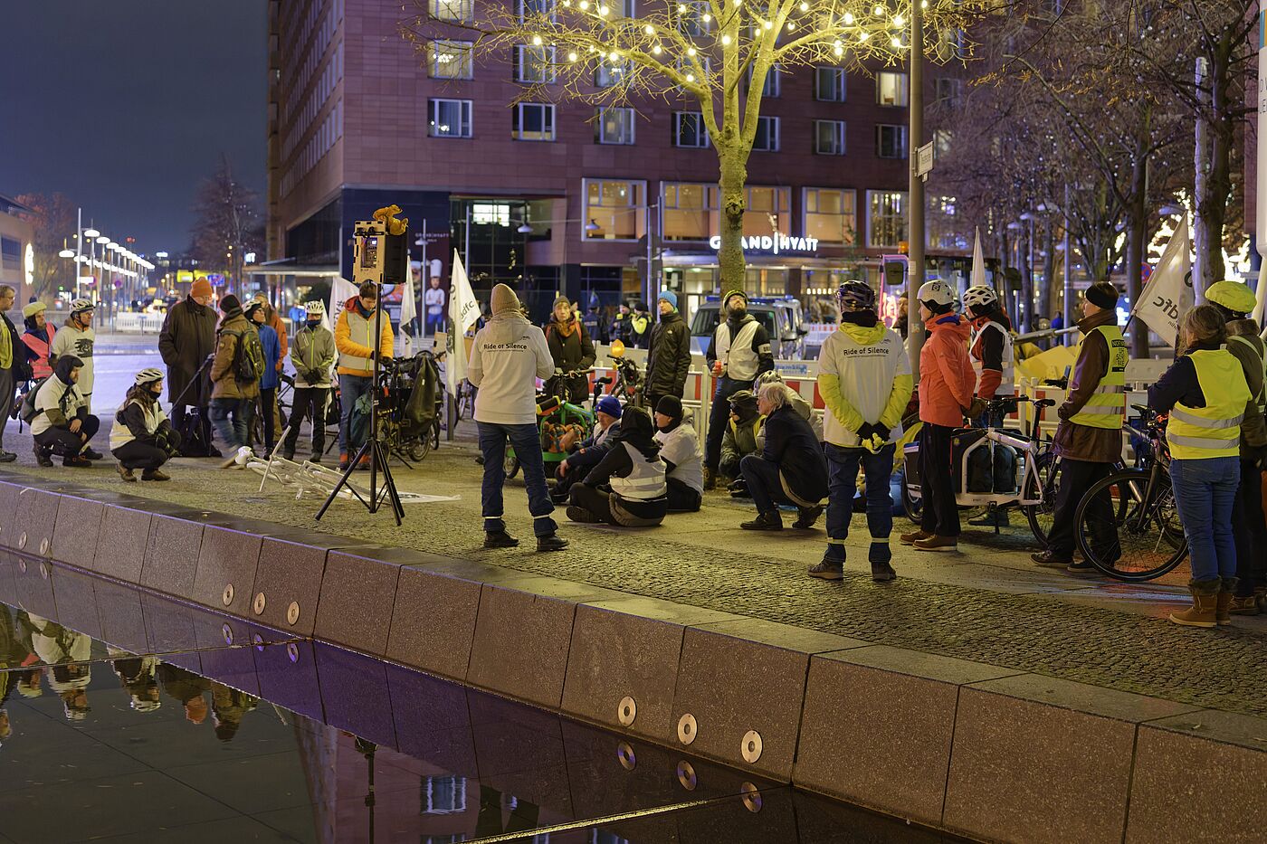 Menschen mit Warnwesten stehen bei einer Mahnwache
