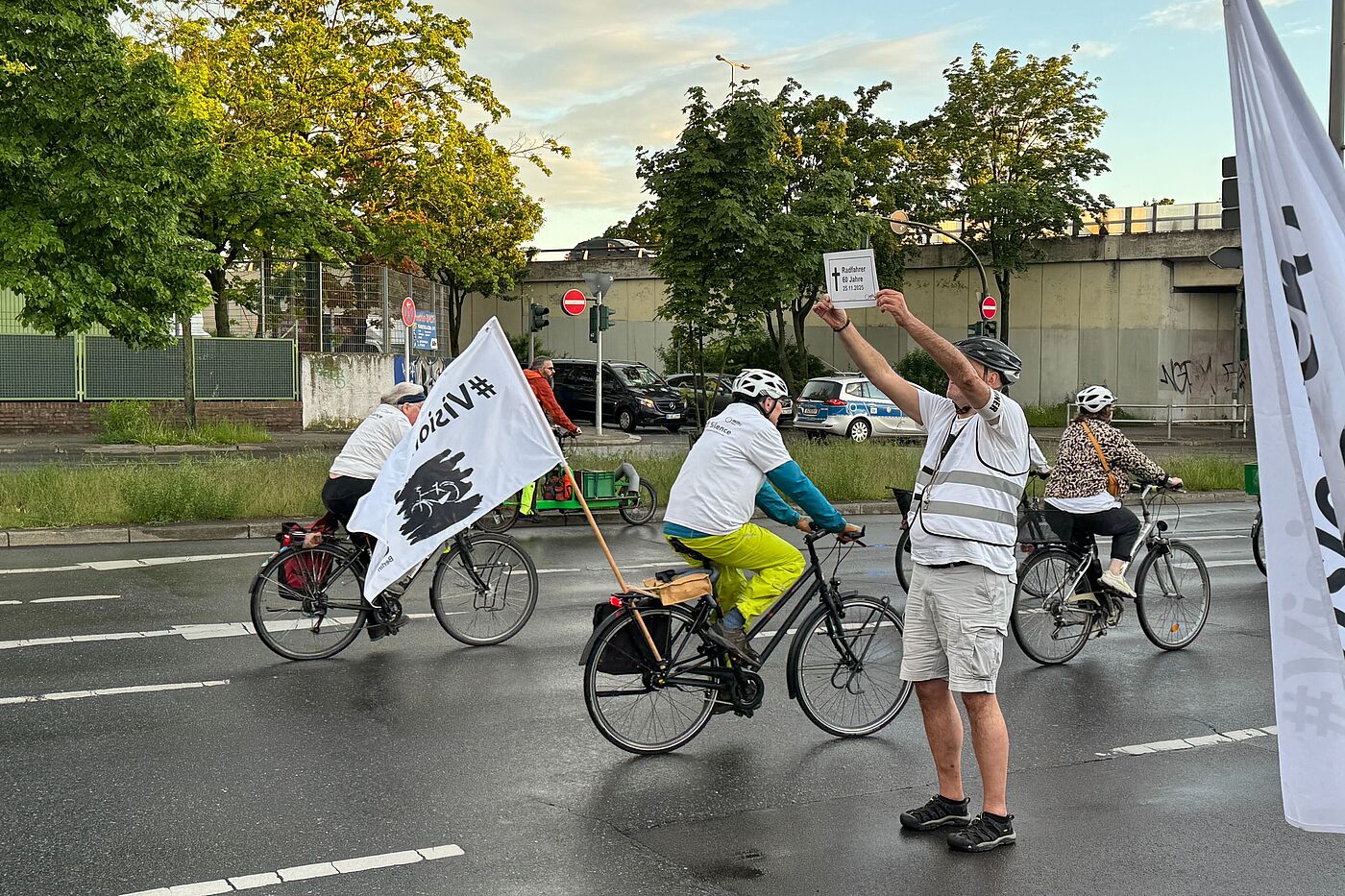 Mensch hält bei einer Fahrraddemonstration ein weißes Schild zum Gedenken an 2025 verstorbenen Radfahrer