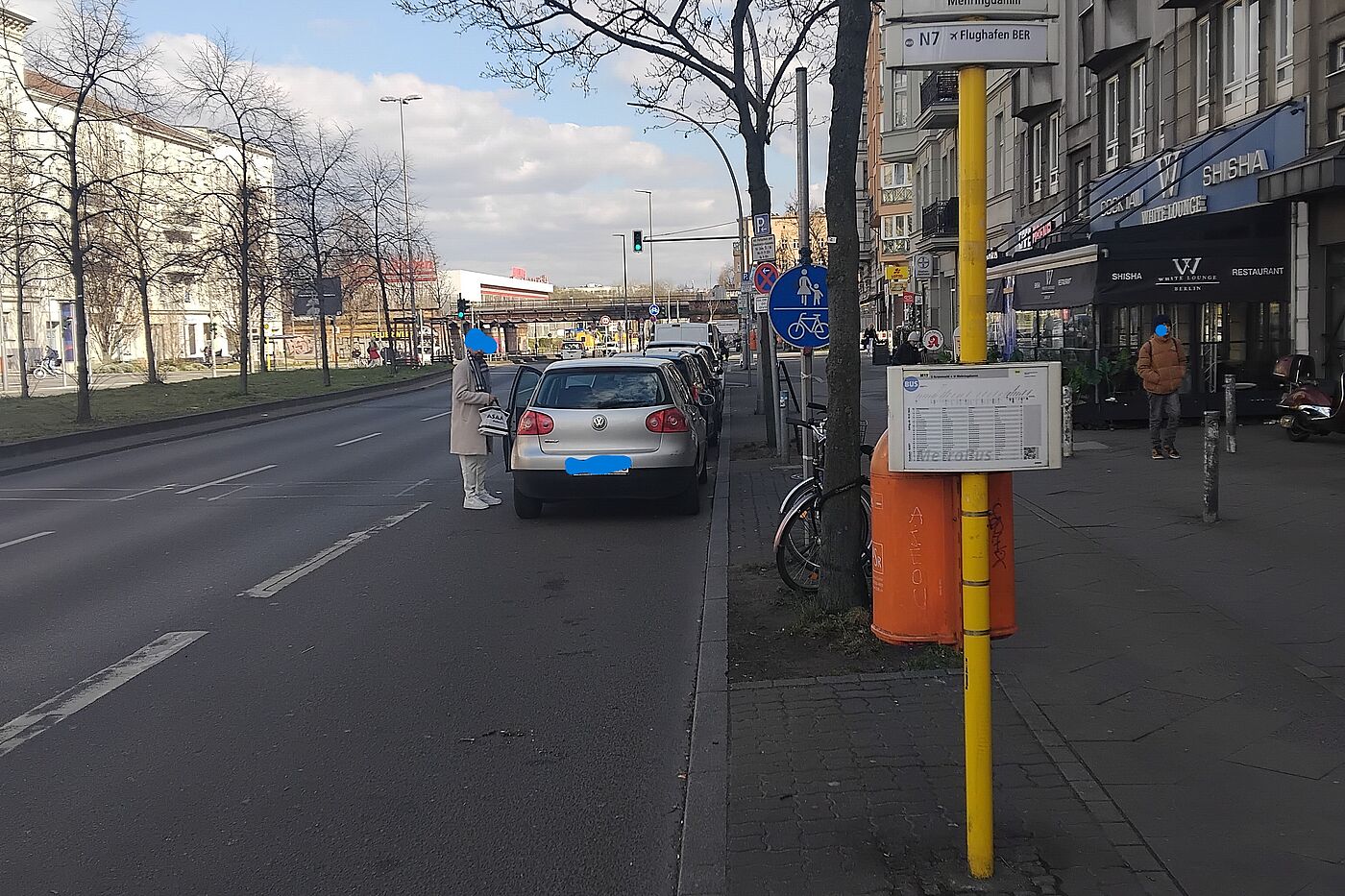 Das Bild zeigt eine Bushaltestelle, wobei der Bus in der gleichen Spur mit zu nah parkenden Autos halt. 