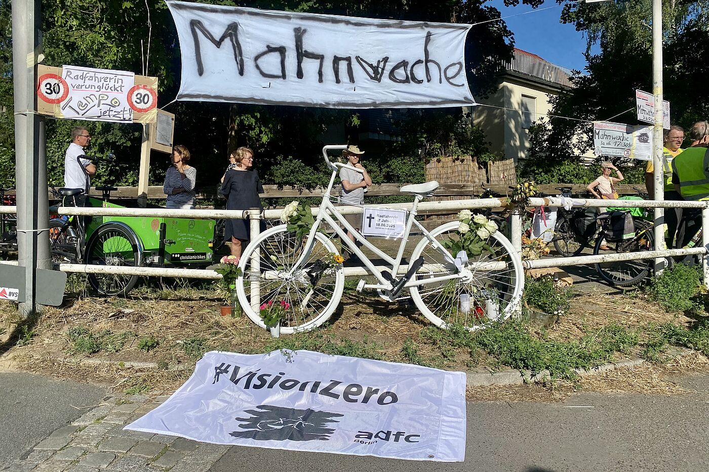 Eine weiße VisionZero Fahne des ADFC Berlin kennzeichnet die Stelle, an der eine Radfahrerin auf der Berliner Clayallee angefahren wurde.
