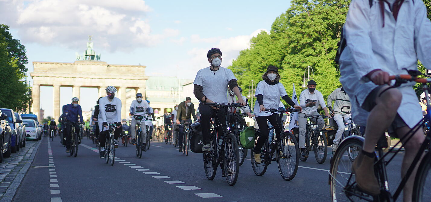 weiß gekleidete Radfahrende beim Ride of Silence vor dem Brandenburger Tor