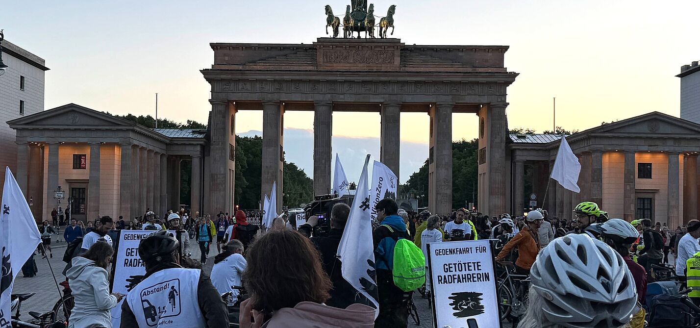 Radfahrende überwiegend in weiß gekleidet vor dem Brandenburger Tor