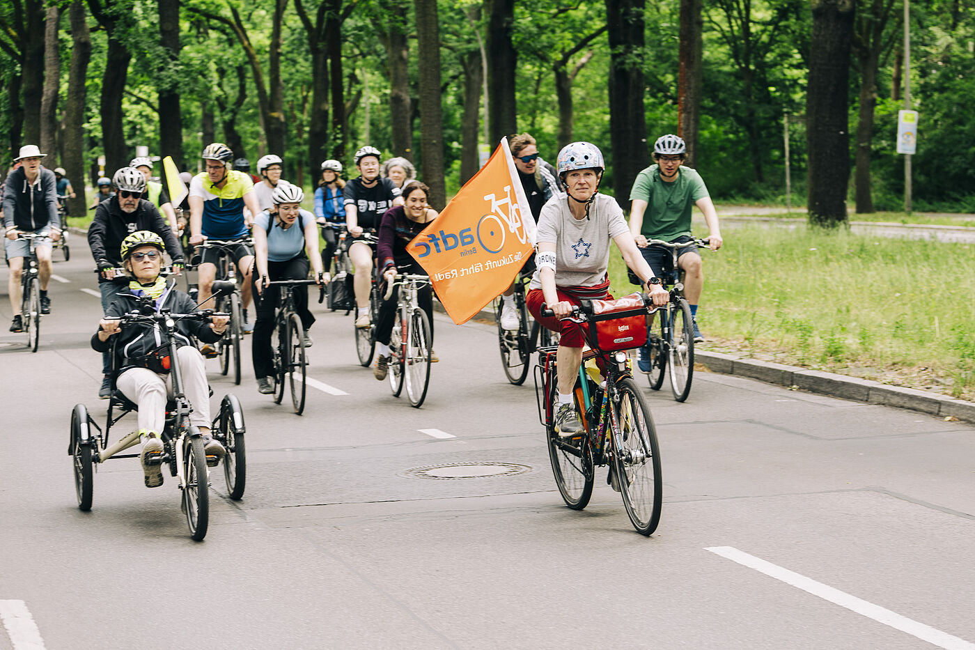 Sternfahrt Helferin mit grauem T-Shirt und oranger ADFC Fahne