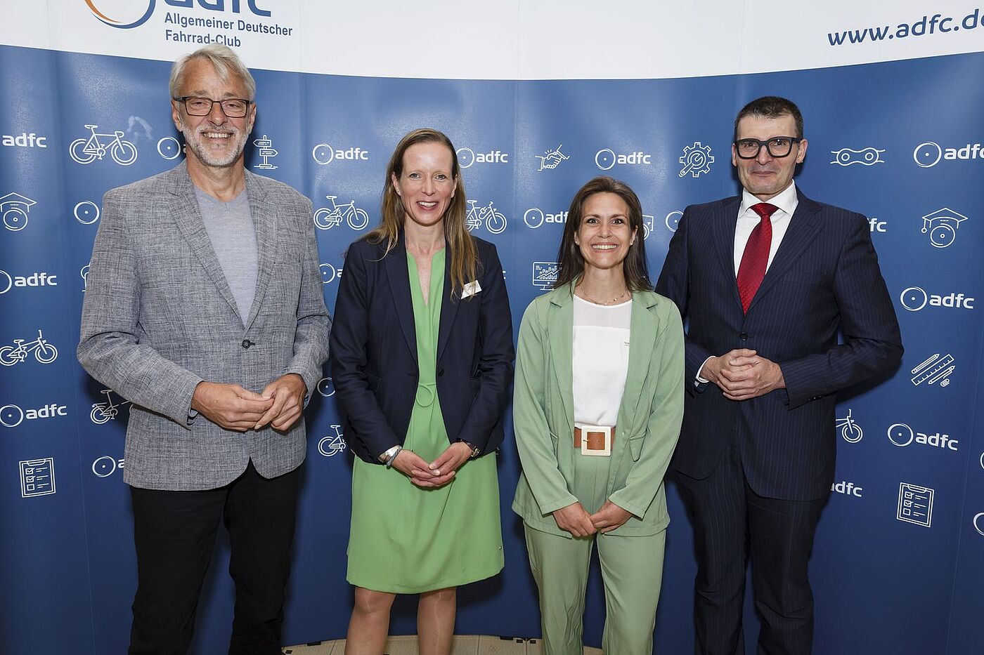 ADFC | Parlamentarischer Abend am 6. Juni 2024 Aufnahme vor Fotowand: Von links nach rechts: ADFC-Bundesvorsitzender Frank Masurat, ADFC-Bundesgeschäftsführerin Caroline Lodemann, stellvertretende ADFC-Bundesvorsitzende Sarah Holczer, Parlamentarischer Staatssekretär Hartmut Höppner.